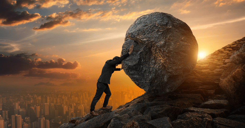A businessman reaching for a large rock at sunset while using the discount code for the WPvivid WordPress plugin.