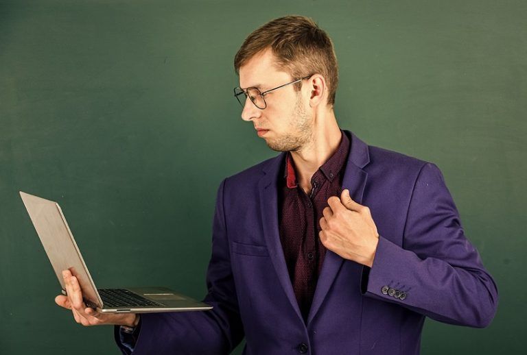 A man in a purple suit using a laptop to install the WPvivid WordPress plugin provided by PlanetHoster.