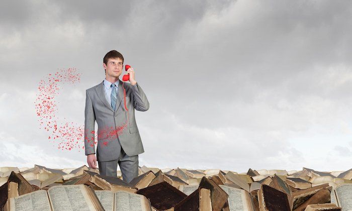 A man in a suit is standing in front of a pile of books, holding a WordPress plugin discount code.