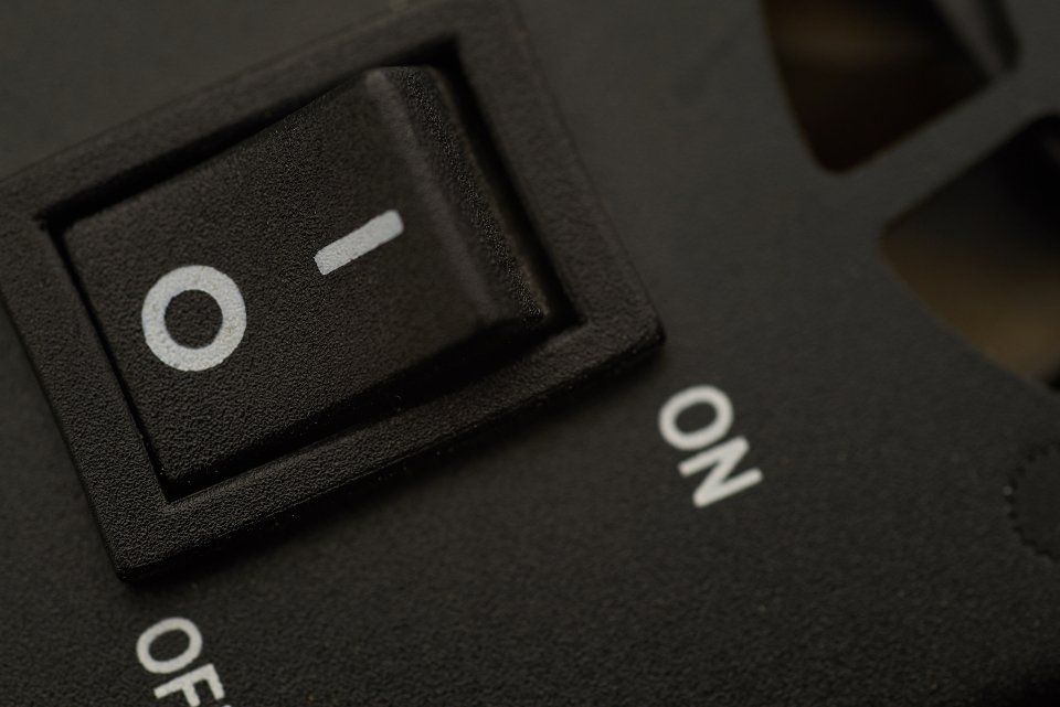 A close up of a black power switch with a discount code for Planethoster.